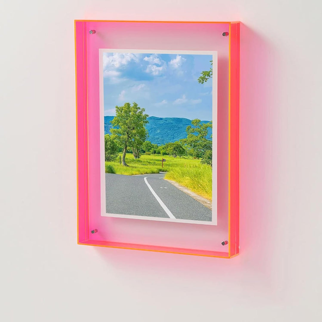 Framed photograph of a scenic road with trees and blue sky, mounted on a white wall.