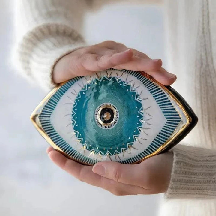 Ceramic eye-shaped dish with intricate design held by a person