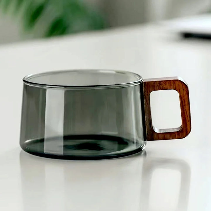 Clear glass mug with a wooden handle on a white surface