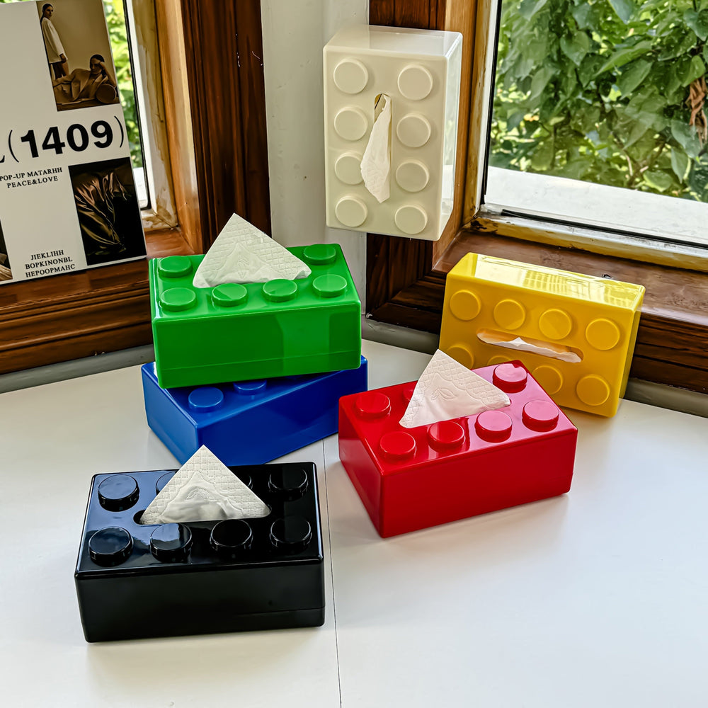 Colorful lego-style tissue boxes on a windowsill with a view of greenery outside.
