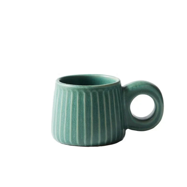 Green ceramic mug with ribbed texture on a white background