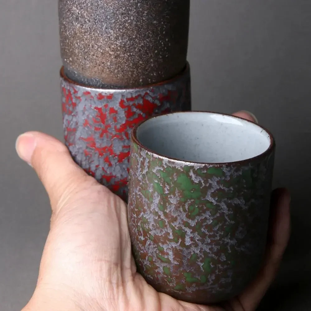 Hand holding a ceramic cup with textured surface against a dark background