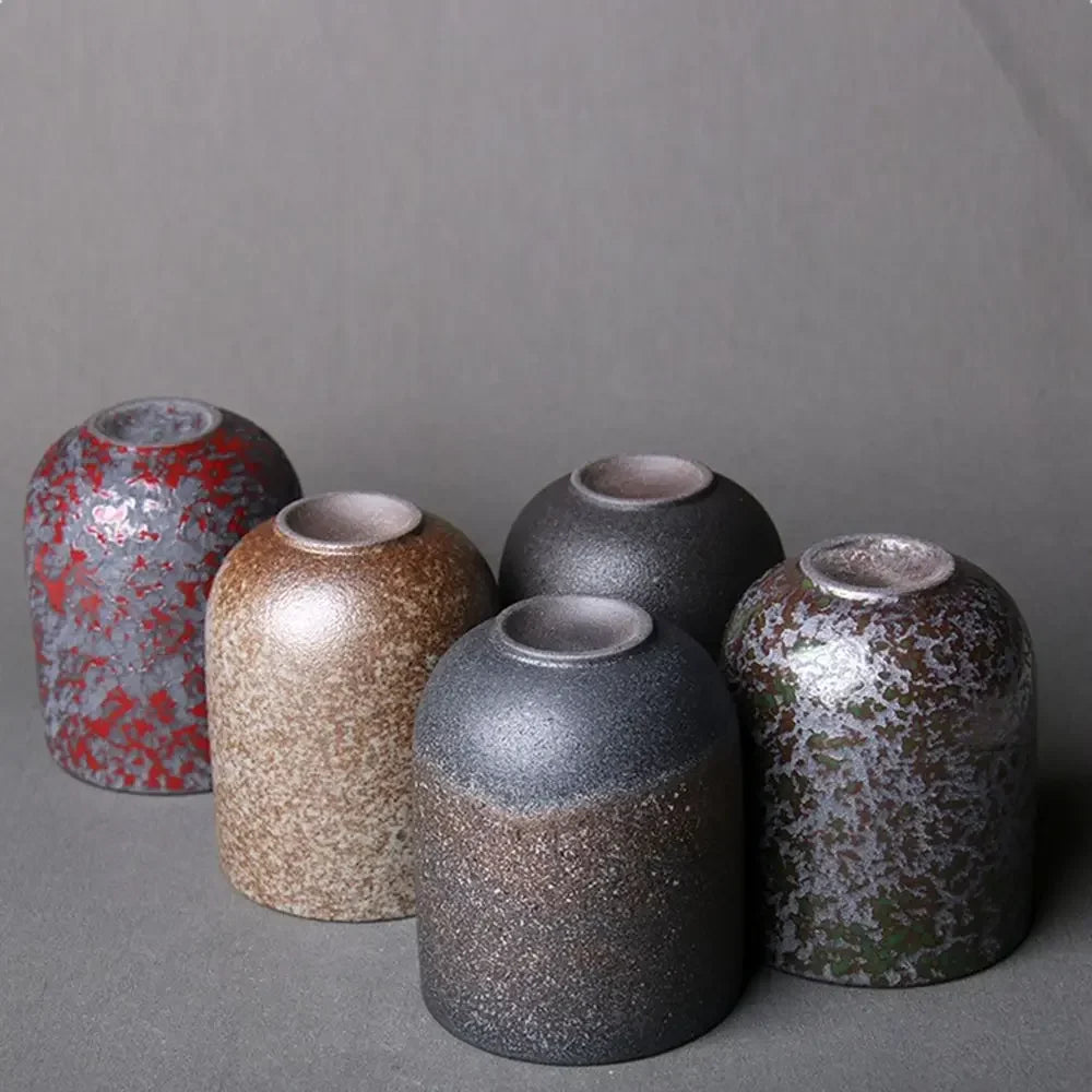 Set of five ceramic vases with textured surfaces on a gray background