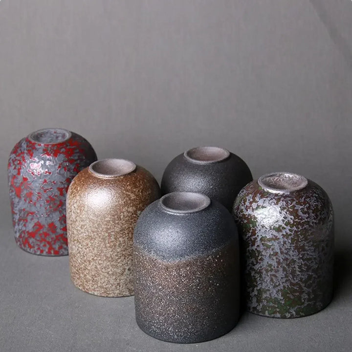 Set of five ceramic vases with textured surfaces on a gray background