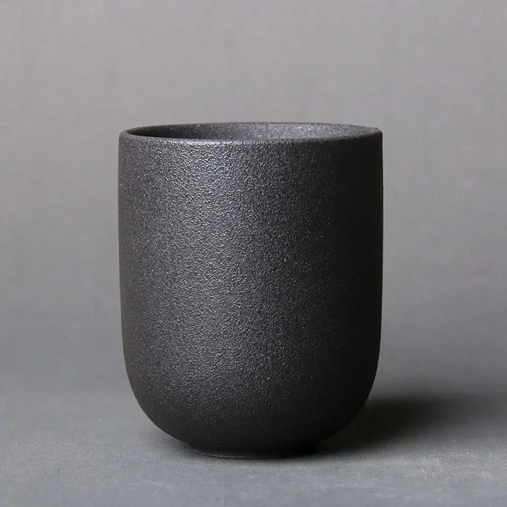 Black textured ceramic cup on a gray background
