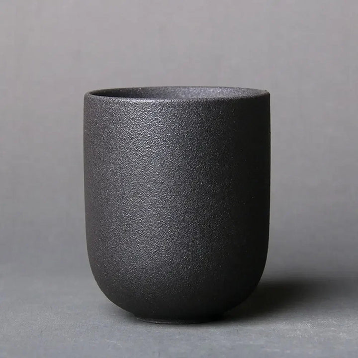 Black textured ceramic cup on a gray background
