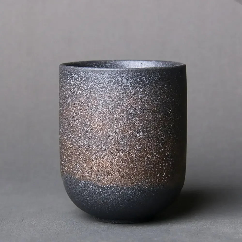 Speckled ceramic cup on a gray background