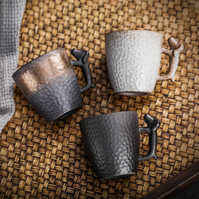 Three ceramic mugs with textured surfaces on a woven mat