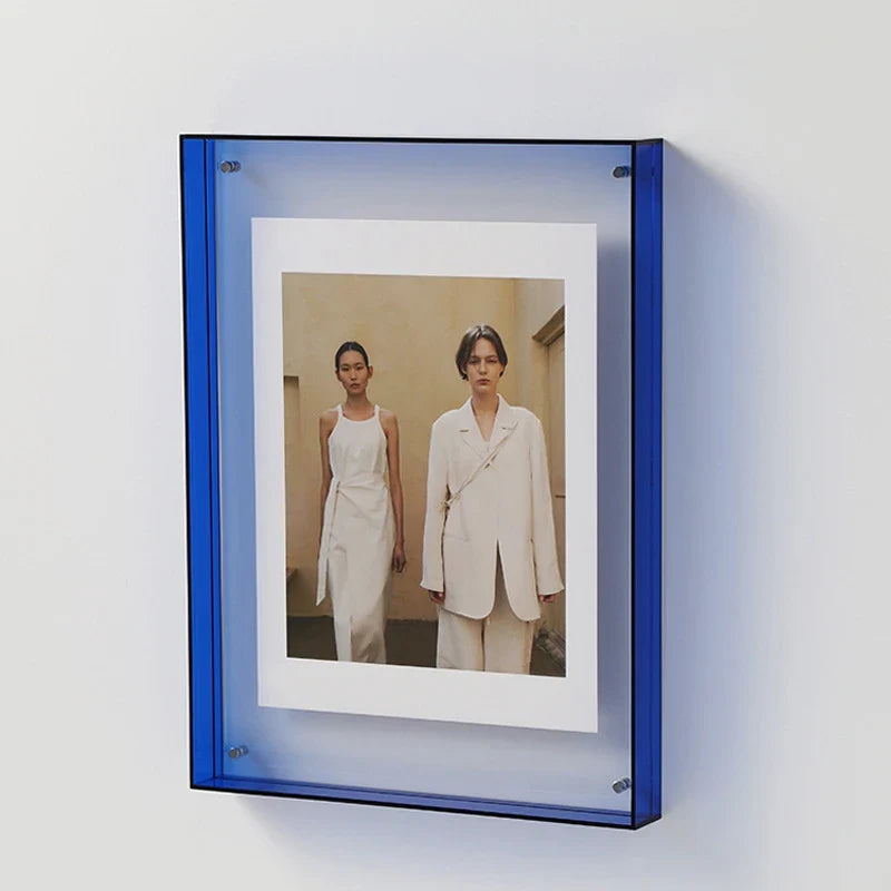 Framed photograph of two people in white outfits on a white wall