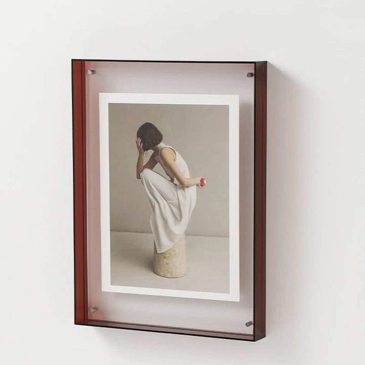 Framed photograph of a woman in a white dress against a beige background