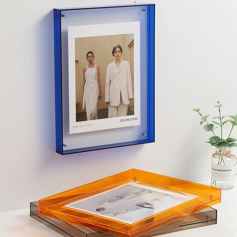 Framed picture of two people in white outfits with a blue frame, placed on a white surface.