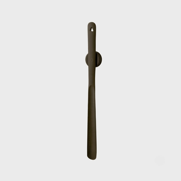 A single matte dark brown wall hook with a hanging loop at the top, shown against a solid light gray background.