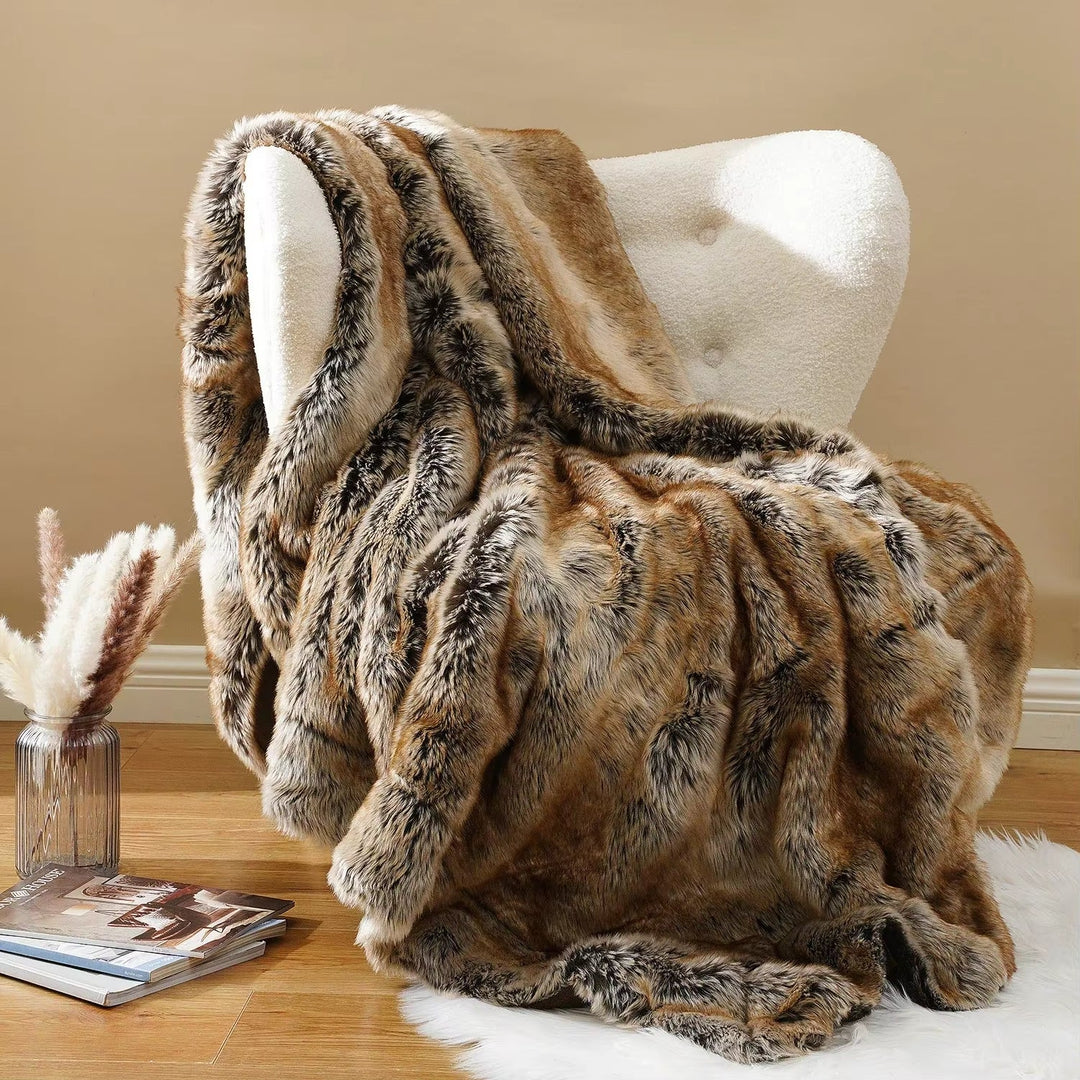 Brown faux fur blanket draped over a white chair against a beige wall.
