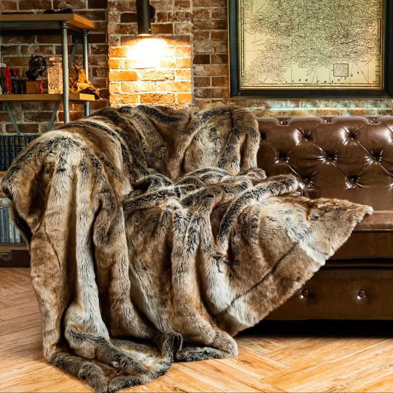Brown fur throw blanket draped over a brown leather sofa in a cozy room with brick walls and a map.