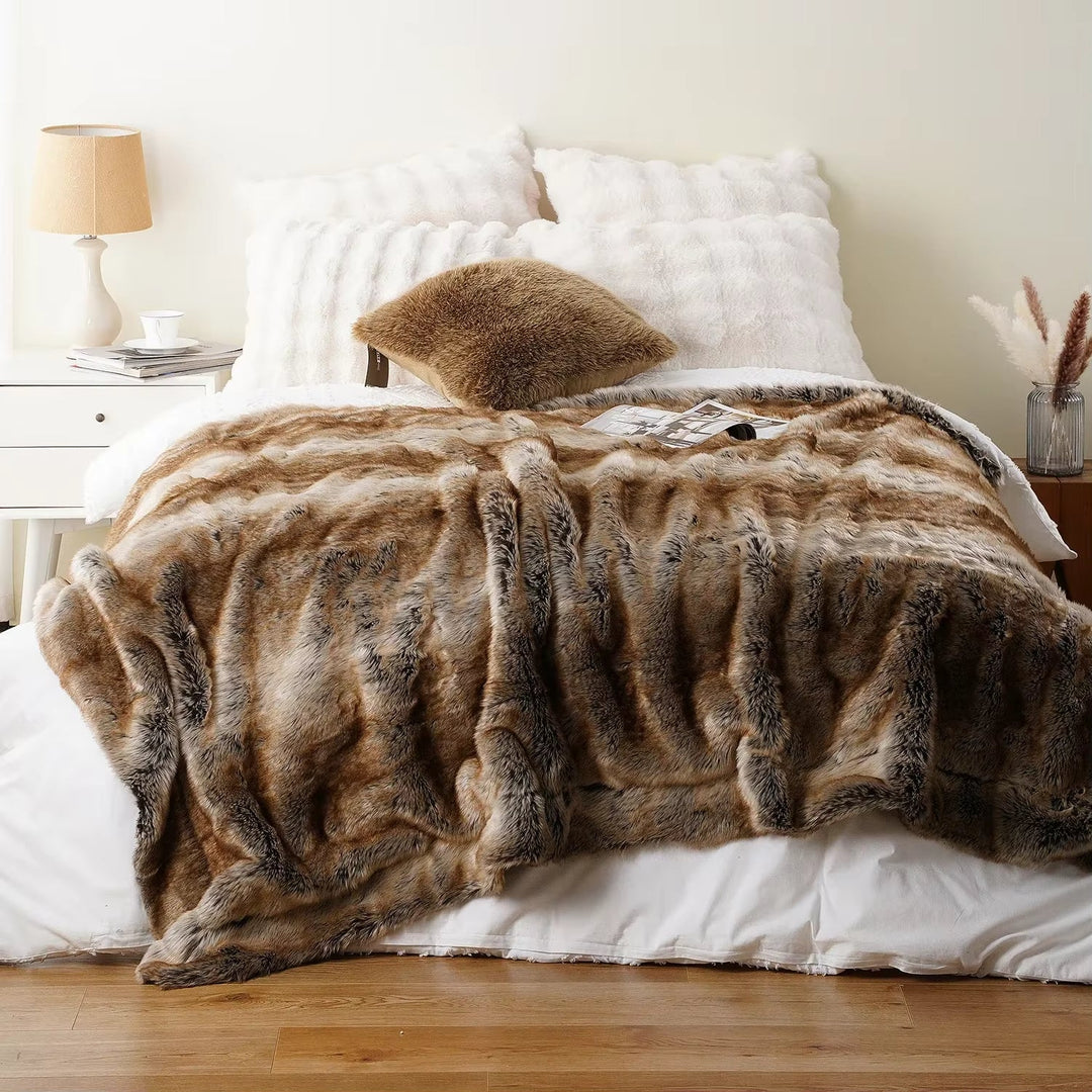 Brown faux fur blanket draped over a bed in a bedroom setting.