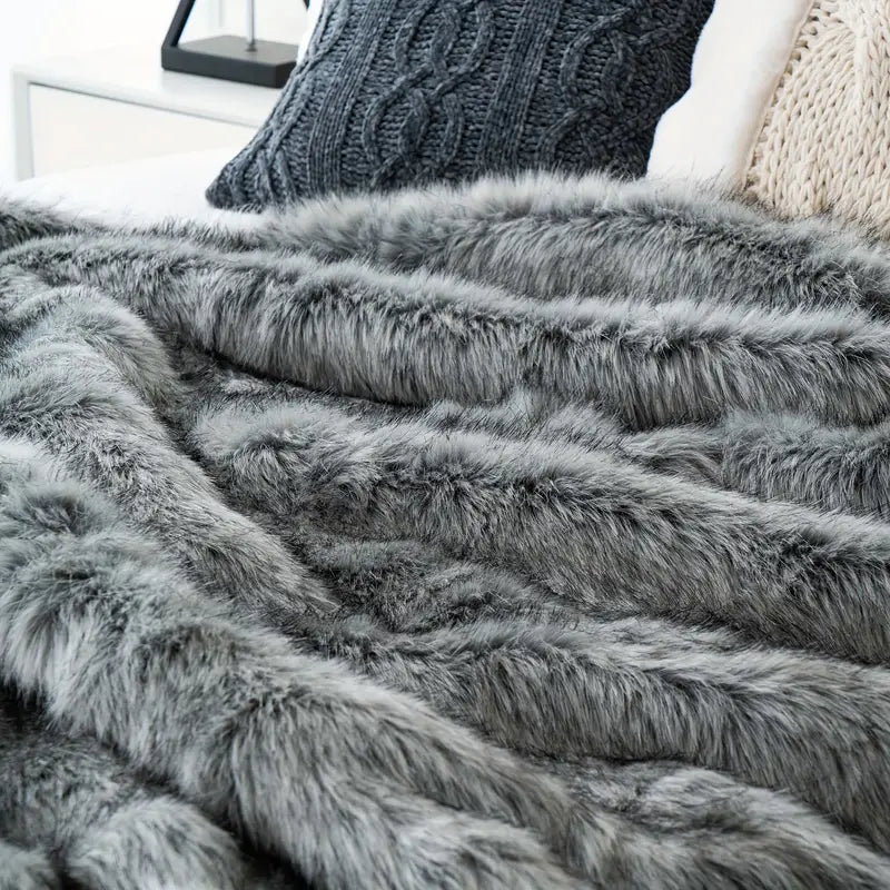 Gray fluffy blanket draped over a surface with a blurred background
