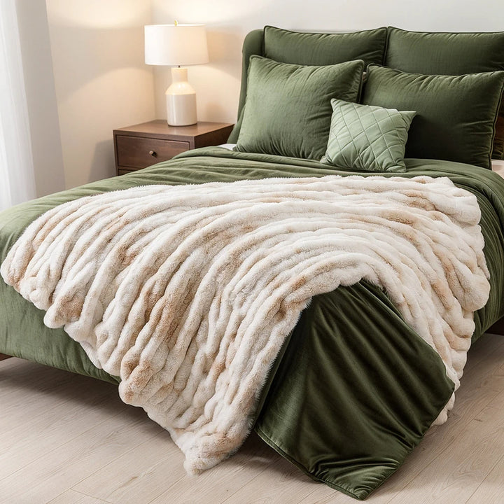 Green bed with beige blanket in a bedroom setting