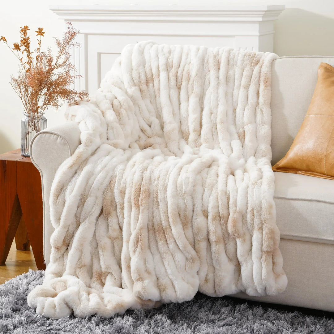 White textured blanket draped over a sofa in a living room setting.