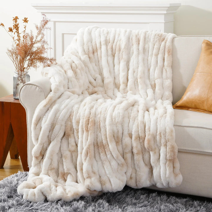 White textured blanket draped over a sofa in a living room setting.
