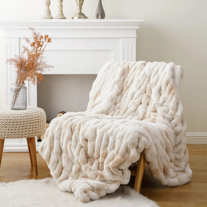 White fluffy blanket draped over a chair in a cozy living room.