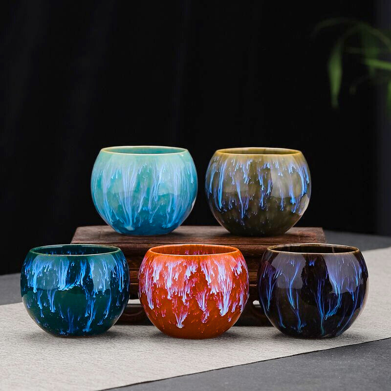 Five colorful ceramic cups on a dark background