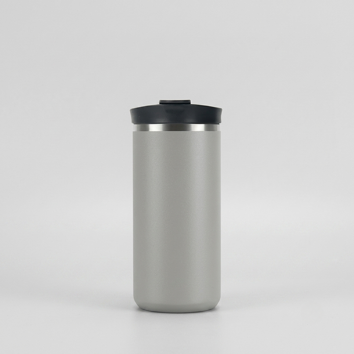 A matte gray insulated travel tumbler with a black lid and a thin silver metallic band, centered on a light gray background.