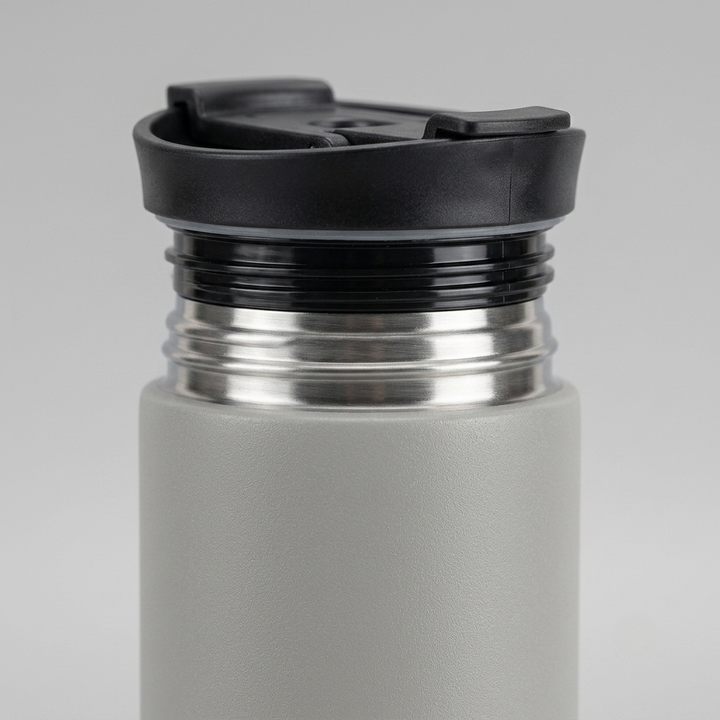 Close-up of a matte gray insulated bottle with a black flip-top lid and a stainless steel neck, shown on a light gray background.