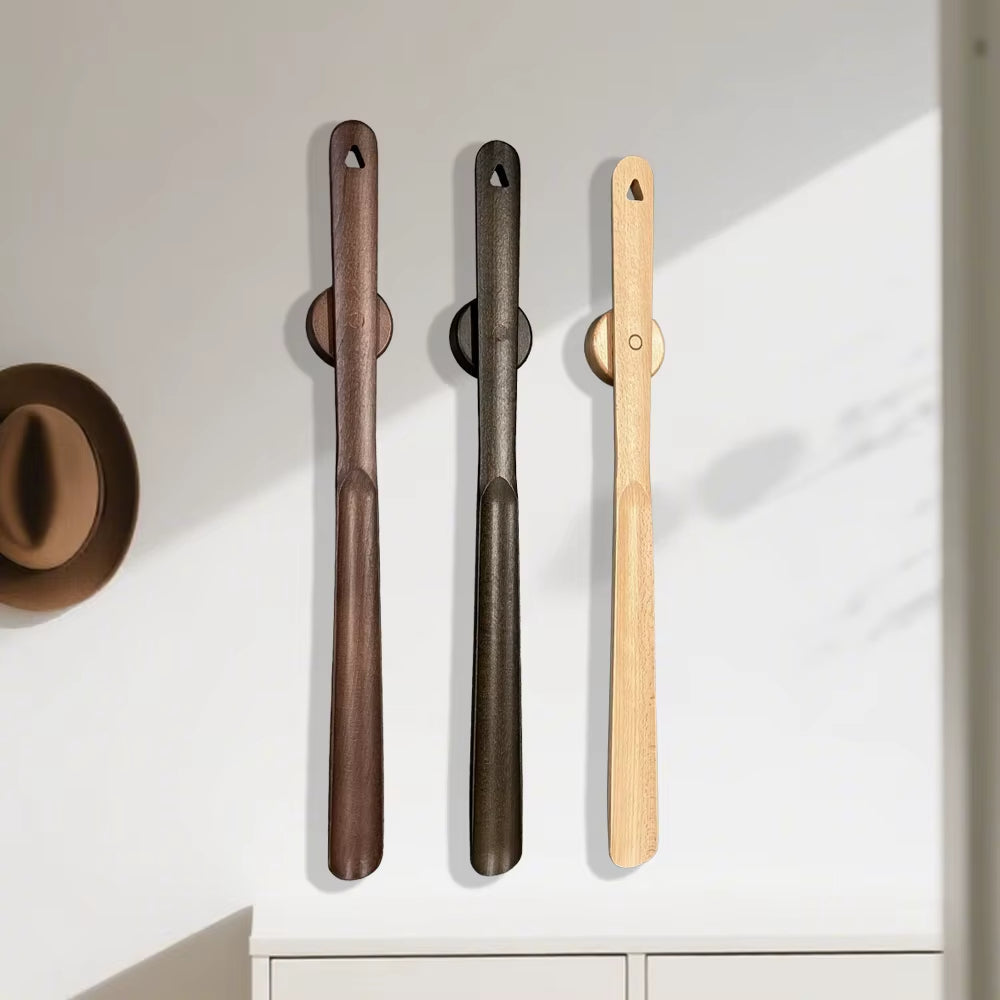 Three wooden door handles in different finishes on a white cabinet.