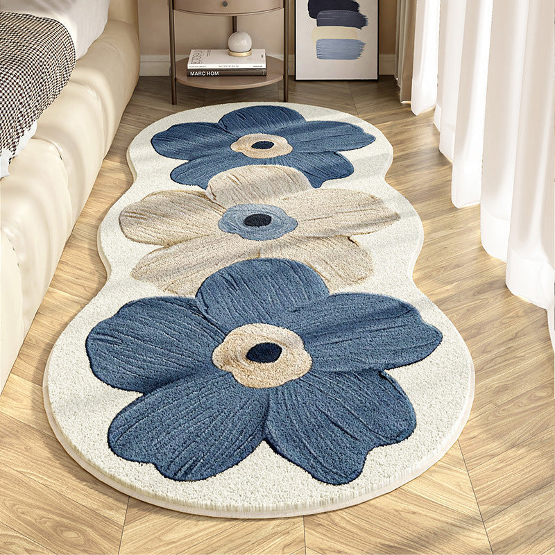 Floral-patterned rug with blue and beige flowers on a wooden floor.
