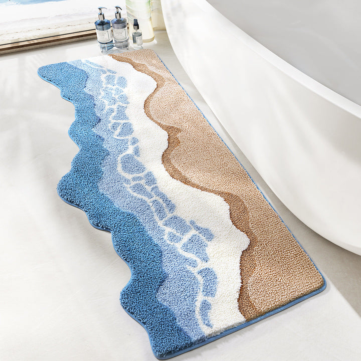 Bath mat with wavy design in blue, beige, and white on a bathroom floor.