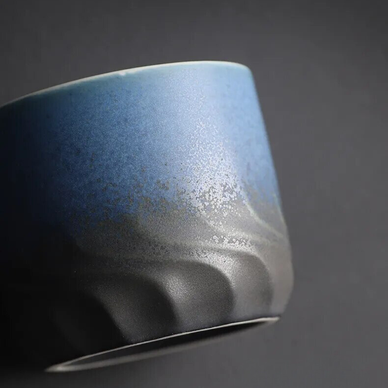 Blue ceramic cup with a textured surface on a dark background
