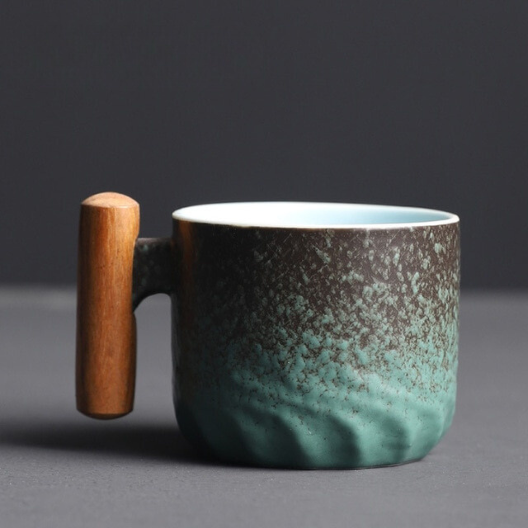 Teal ceramic mug with wooden handle on a dark background