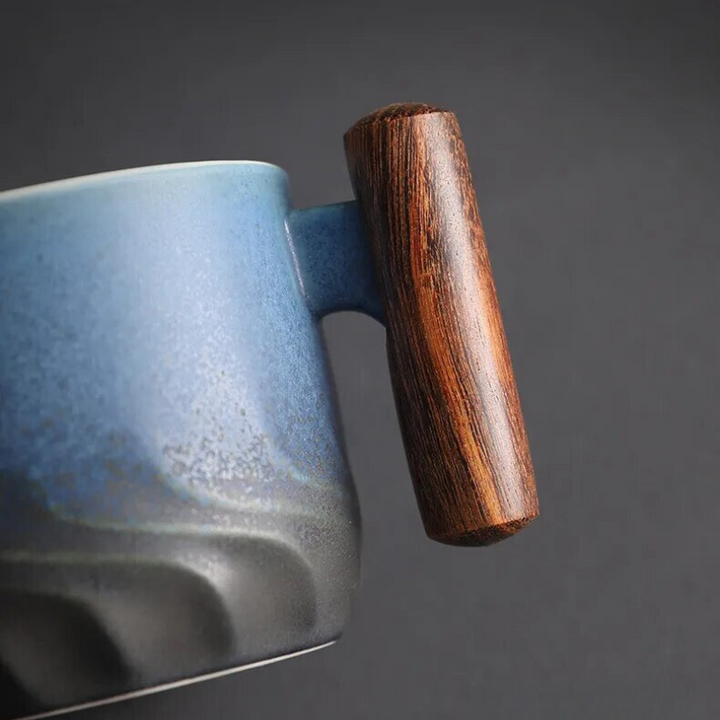 Blue ceramic mug with a wooden handle on a dark background