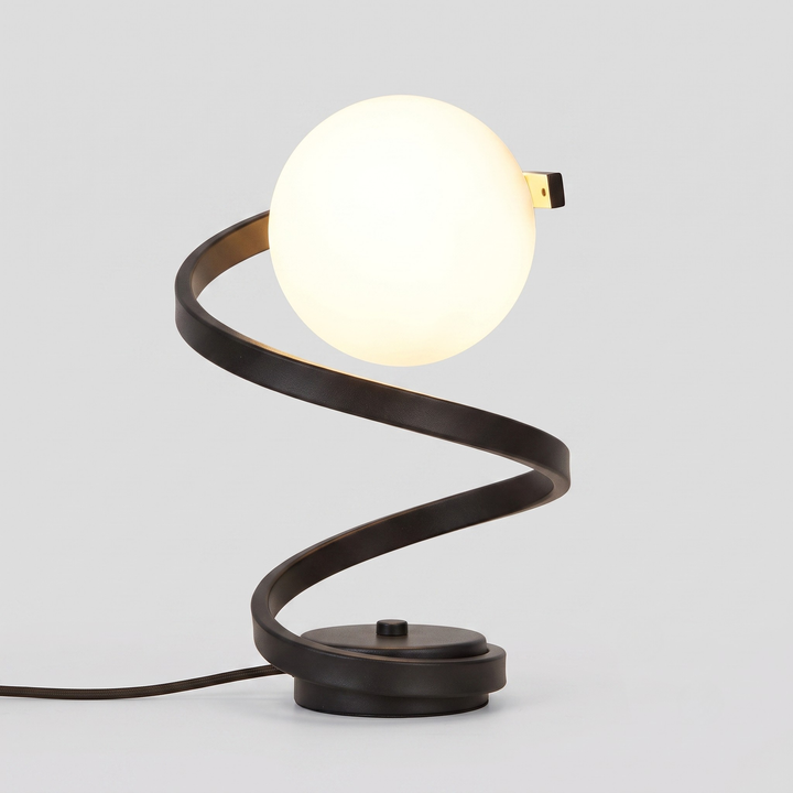 A modern spiral table lamp with a glowing white globe shade and a dark bronze metal base, shown against a neutral light gray background.