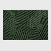 A rectangular dark green textured mat with a raised geometric pattern of interlocking diagonal ridges, shown flat against a light gray background.