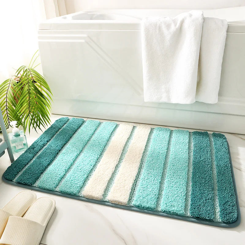 Striped bath mat with green and white colors on a bathroom floor.