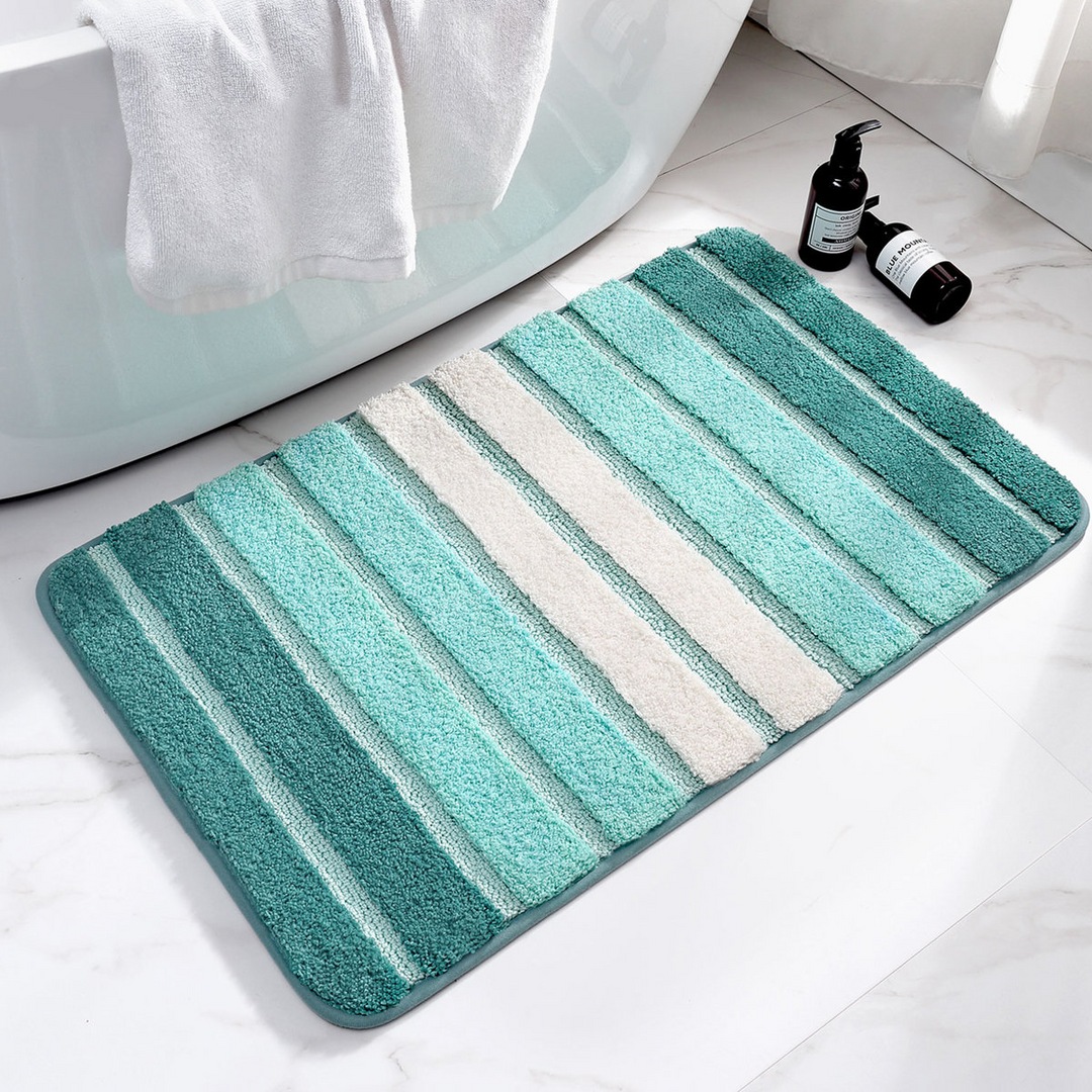 Striped bath mat with gradient colors on a bathroom floor.