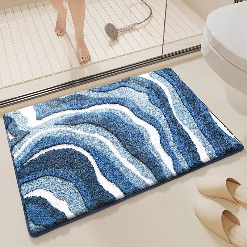 Blue and white patterned bath mat on a bathroom floor with a shower in the background.