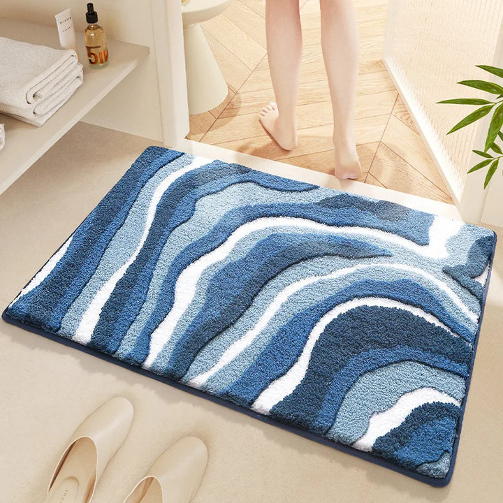 Blue wavy patterned rug on a bathroom floor with a person stepping onto it.