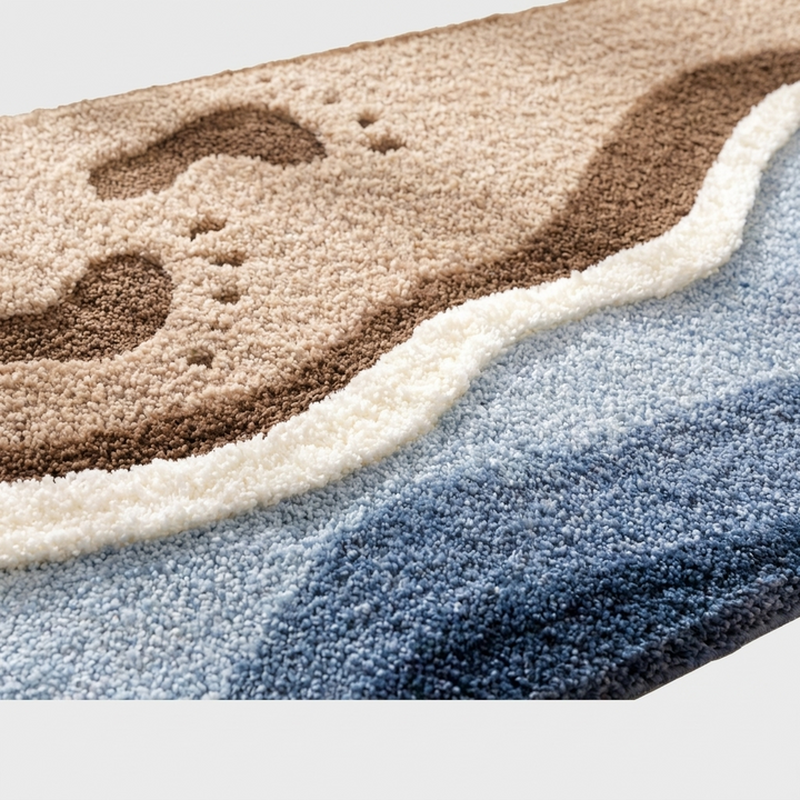 Close-up of a textured area rug with a layered design featuring a tan and brown footprints motif on top, a white wave-like border, and blue and gray lower sections.