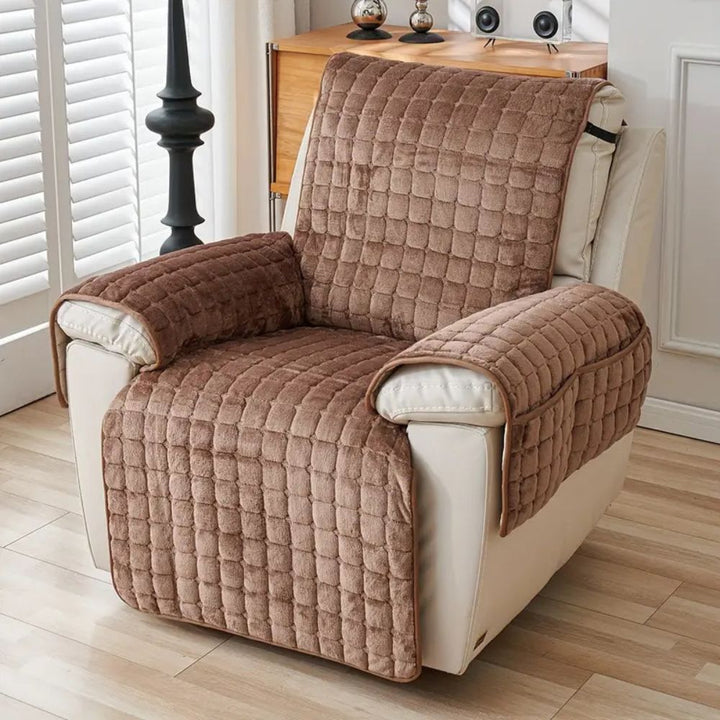 Brown quilted chair cover on a beige armchair in a room with wooden floor and white walls.