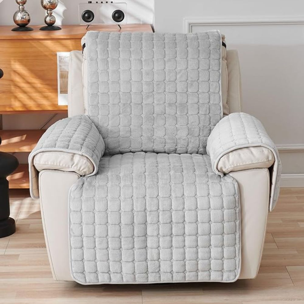 Gray quilted armchair cover on a beige armchair in a living room setting.