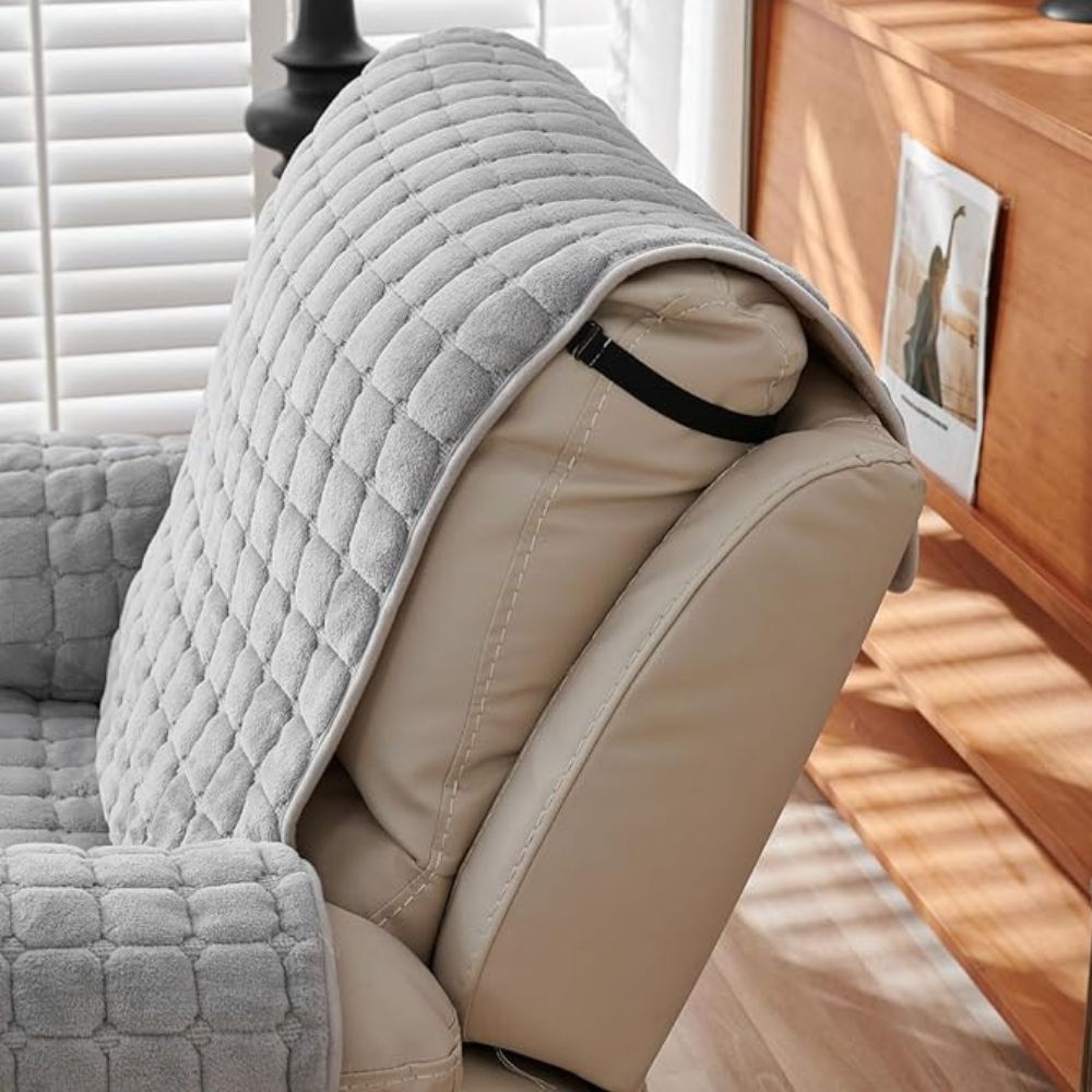Gray quilted cover on a beige chair with a wooden cabinet in the background