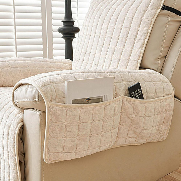 Beige quilted armrest organizer on a beige sofa with remote control and tablet.