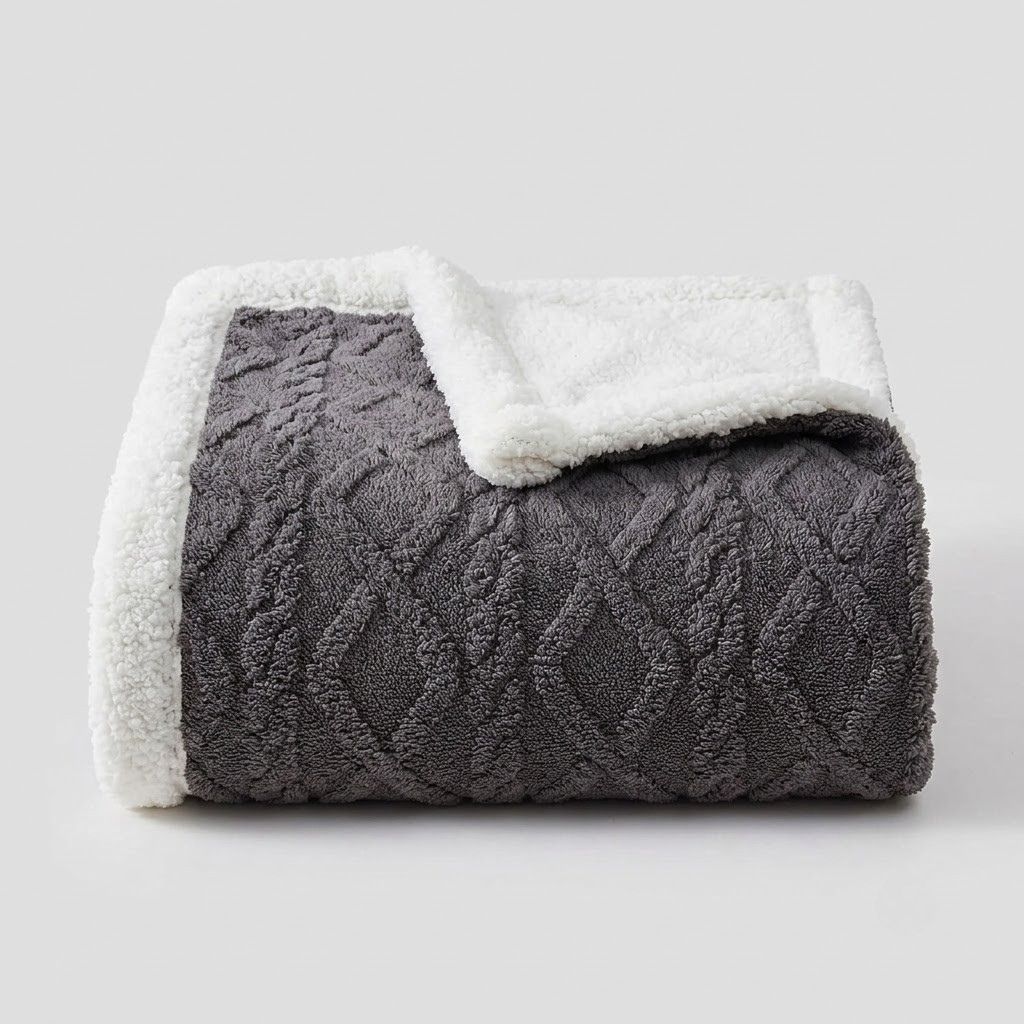 A folded throw blanket with a dark gray textured diamond-patterned front and a soft white sherpa fleece backing, shown on a light gray background.