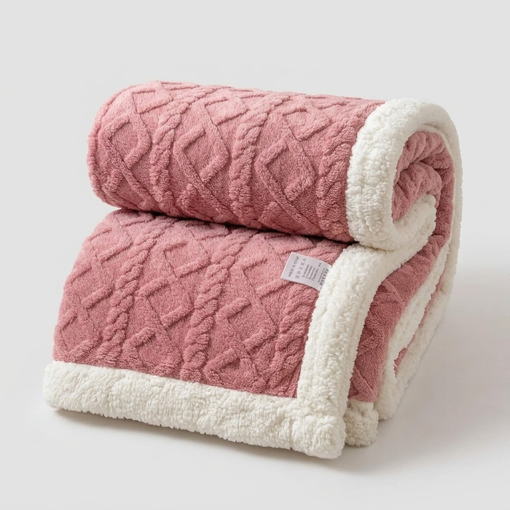 A folded dusty pink textured blanket with a soft white sherpa fleece border, shown on a light gray background.