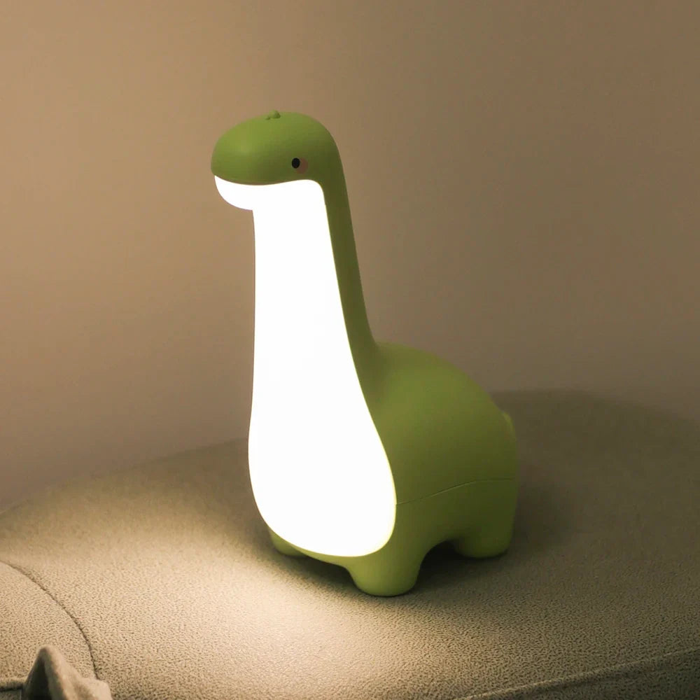 Green dinosaur-shaped night light on a surface with a beige background