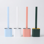 Four minimalist toilet brush holders with matching handles in light blue, white, pink, and dark green, arranged side by side on a light gray background.