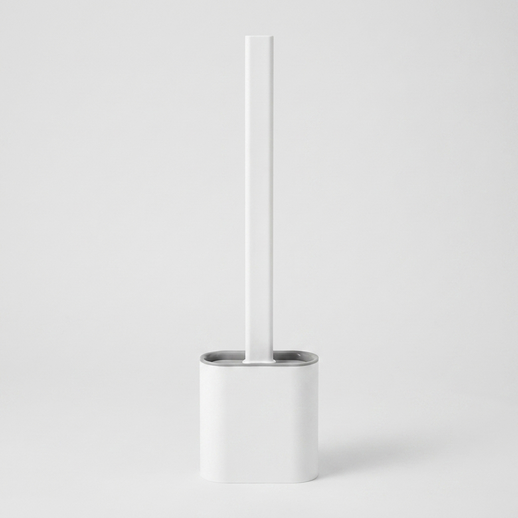 A minimalist white toilet brush with a matching white cylindrical holder and a brushed silver metal rim, set against a seamless light gray studio background.