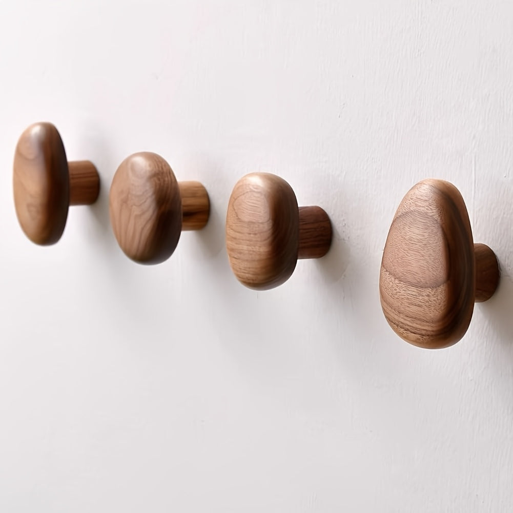Four wooden wall hooks on a white background
